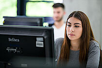 Eine junge Frau arbeitet konzentriert am Computer