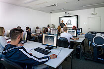 Blick von hinten über die Schultern der Seminarteilnehmer und Seminarteilnehmerinnen im IT-Raum am ELBCAMPUS